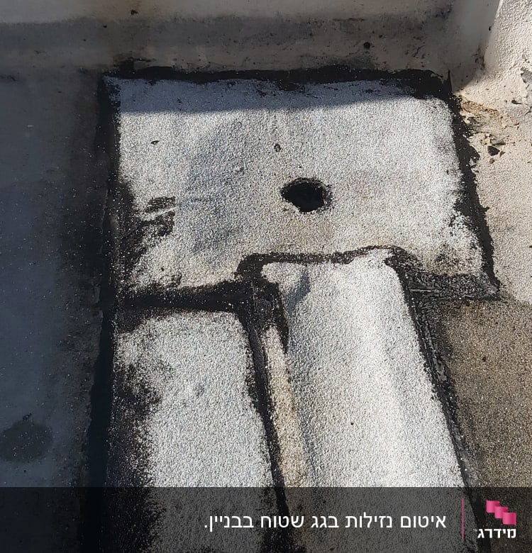 אזור אטום עם חומר איטום שחור על גג בטון